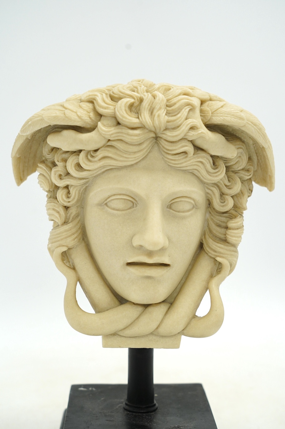 A decorative resin bust of Medusa and a pair of brass candle stands, 40cm. Condition - fair